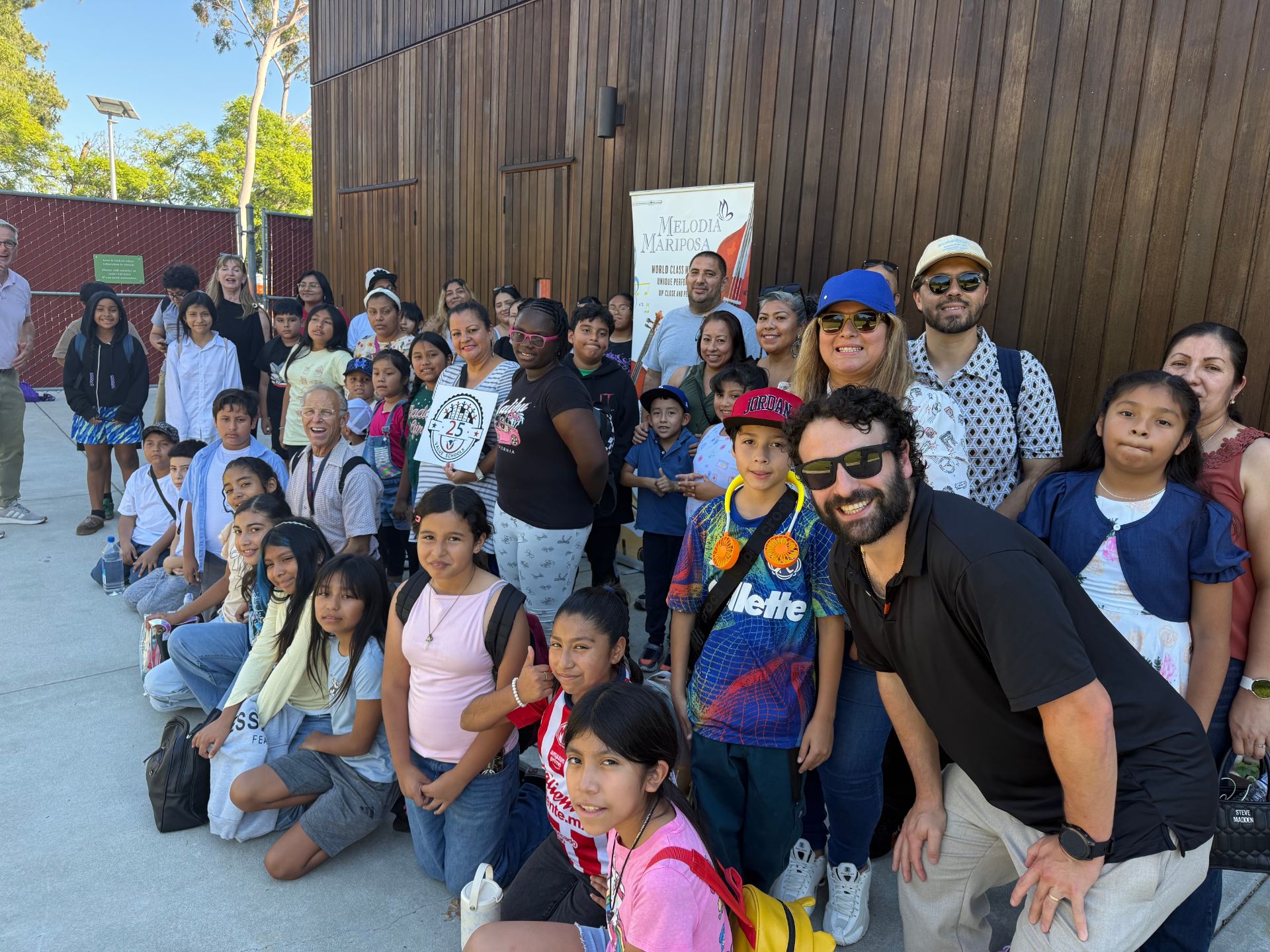 a group of kids and adults waiting in line to get into a concert 