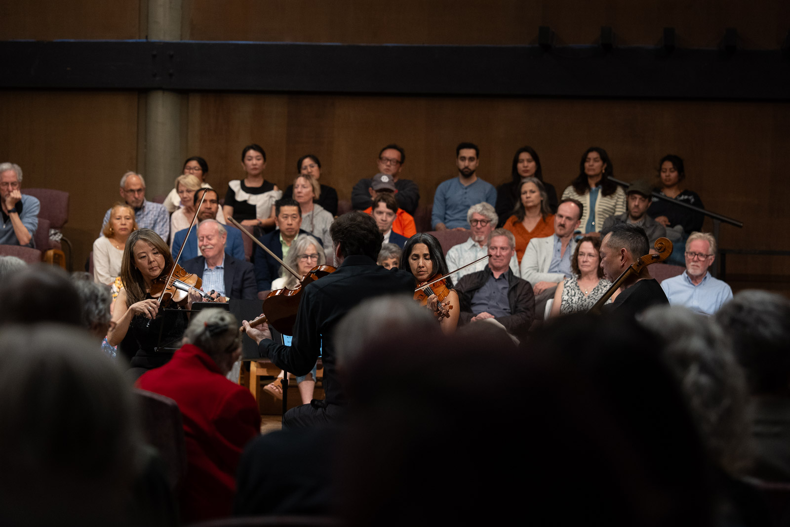 a group of people listening to a violin quartet