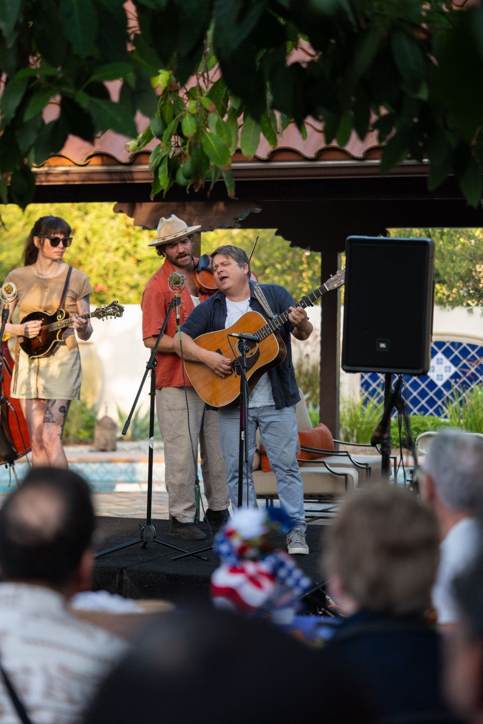 a man on a guitar singing to a crowd of people 
