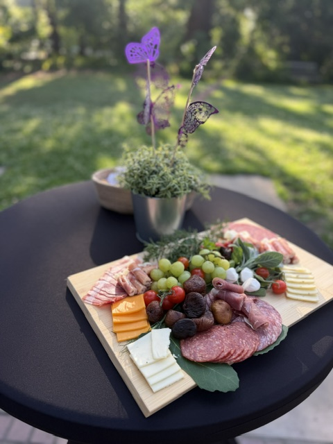 a cheese and meat platter on a black table