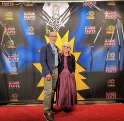 a woman in a pink dress standing with a taller man on a red carpet